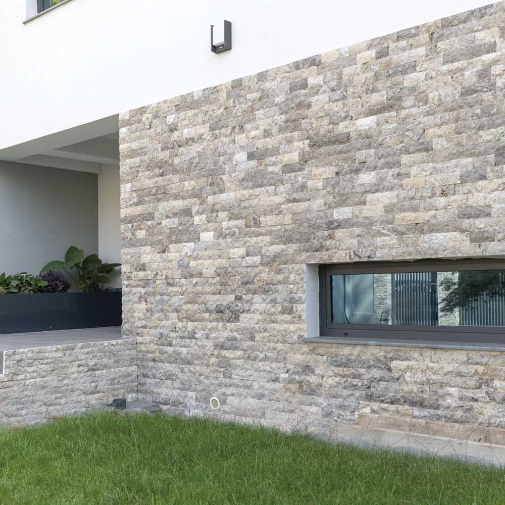 Fachada moderna com Rock Face de Travertino Silver ao lado da janela